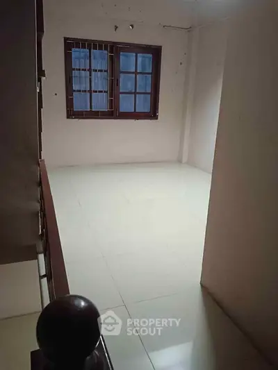 Spacious unfurnished room with large window and tiled flooring
