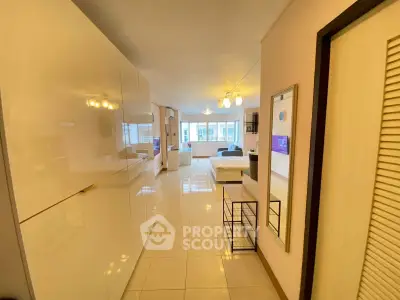 Spacious modern living room with sleek white cabinets and large windows offering ample natural light.