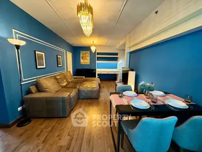 Stylish living room with blue walls, elegant chandelier, and cozy dining area.