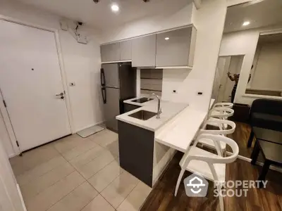 Modern kitchen with sleek cabinetry and breakfast bar in stylish apartment