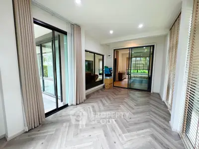 Spacious modern living room with large windows and elegant flooring