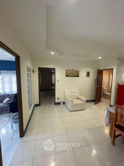 Spacious living area with modern decor and tiled flooring