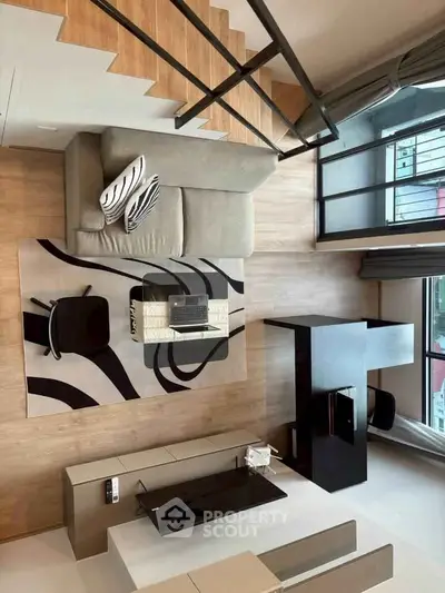 Modern living room with stylish furniture and large windows offering natural light and a cozy atmosphere.