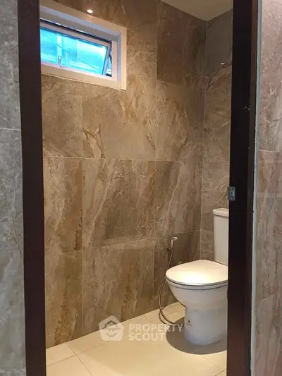 Modern bathroom with elegant stone tiles and sleek toilet design