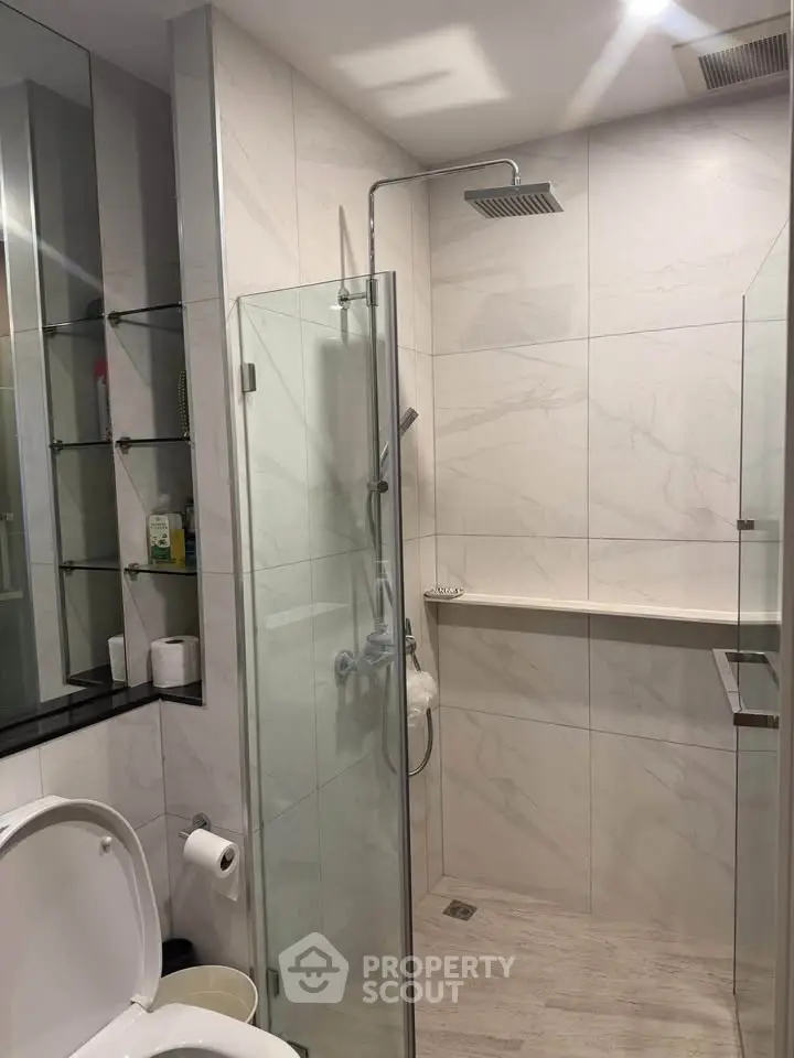 Modern bathroom with glass shower enclosure and sleek fixtures