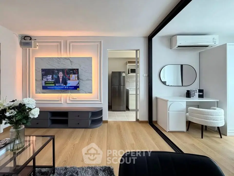 Modern living room with stylish decor, large TV, and elegant furniture, showcasing a chic and inviting atmosphere.