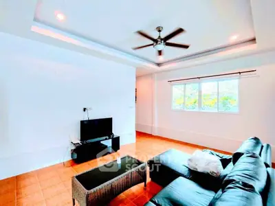 Spacious living room with modern ceiling fan and natural light