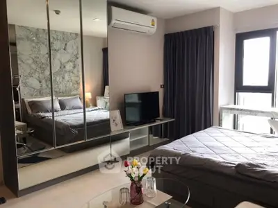 Modern bedroom with mirrored wardrobe and cozy decor in stylish apartment.