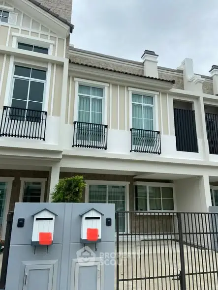 Modern townhouse exterior with stylish facade and secure gated entrance.