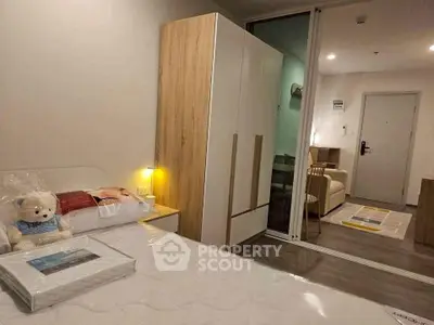 Cozy bedroom with modern furniture and sliding glass door leading to living area.