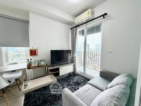 Modern living room with balcony view, featuring sleek furniture and natural light.