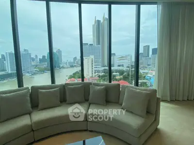 Luxurious living room with panoramic city view and elegant curved sofa.