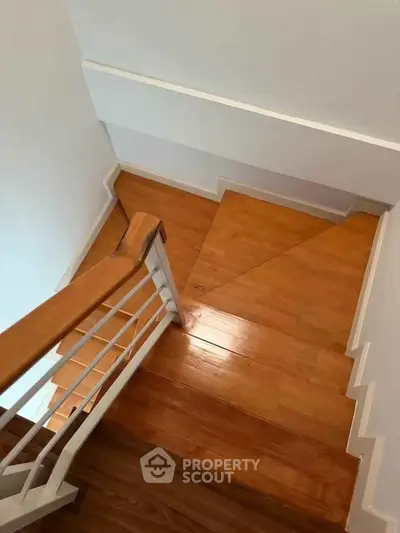 Elegant wooden staircase with modern railing in a contemporary home interior.