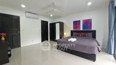 Spacious modern bedroom with stylish decor and ample natural light