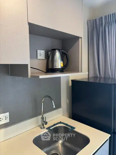 Modern kitchen with sleek sink and electric kettle in compact design