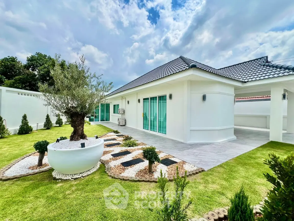 Stunning modern home with lush garden and sleek exterior design under a vibrant sky.
