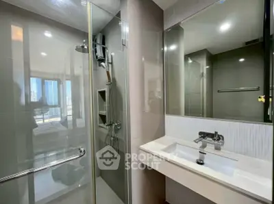 Modern bathroom with glass shower and sleek vanity in luxury apartment