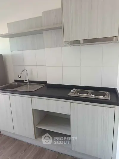 Modern compact kitchen with sleek cabinetry and electric stove