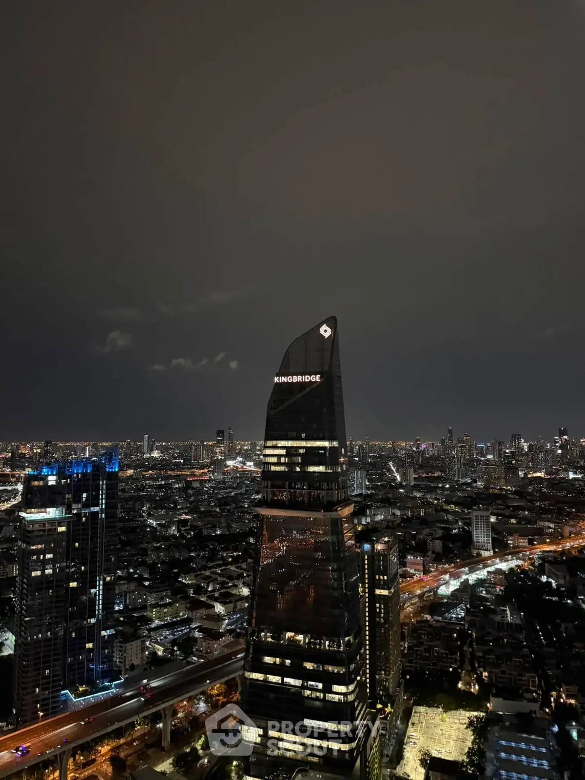 Stunning night view of a modern cityscape with illuminated skyscrapers and bustling streets.