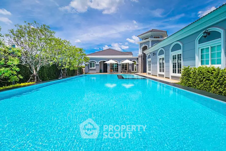 Luxurious villa with a stunning pool and elegant architecture under a clear blue sky.