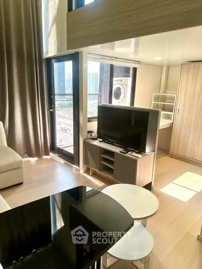 Modern living room with city view, featuring sleek furniture and natural light.