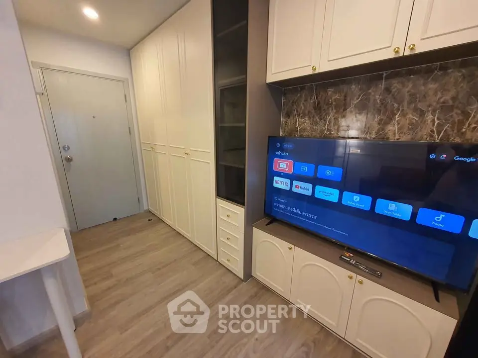 Modern living room with built-in storage and smart TV, featuring sleek design and efficient use of space.