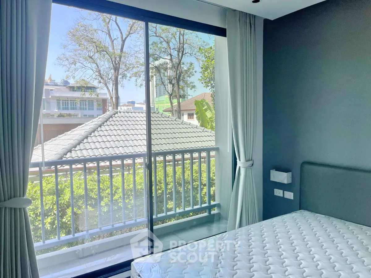 Bright bedroom with large window and balcony view in modern home