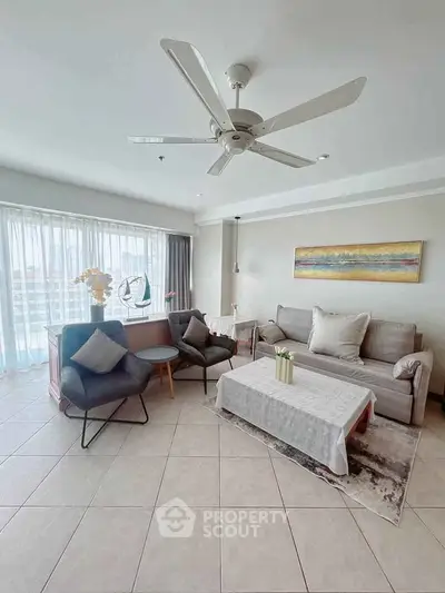 Spacious living room with modern decor and large windows offering natural light.