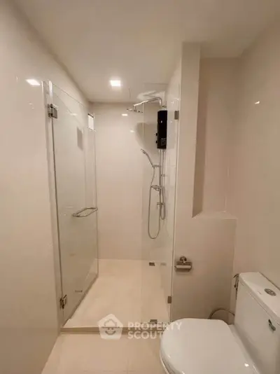 Modern bathroom with glass shower enclosure and sleek fixtures.