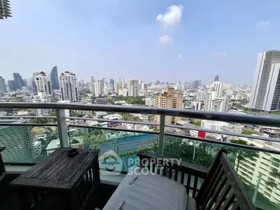Stunning cityscape view from a high-rise balcony with outdoor seating, perfect for urban living.