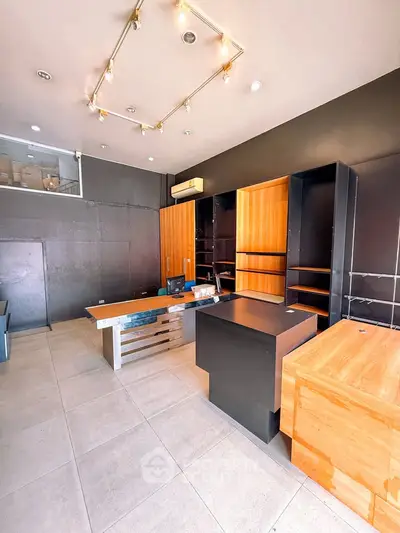 Modern retail space with sleek wooden shelving and stylish lighting, perfect for a trendy boutique or office.