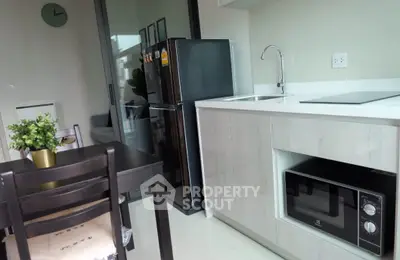 Modern kitchen with sleek appliances and dining area in a stylish apartment.