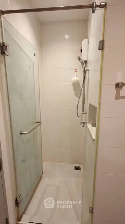 Compact bathroom with glass shower enclosure and modern fixtures.