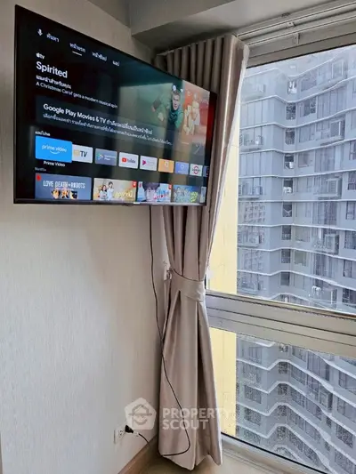 Modern apartment with wall-mounted TV and city view from window