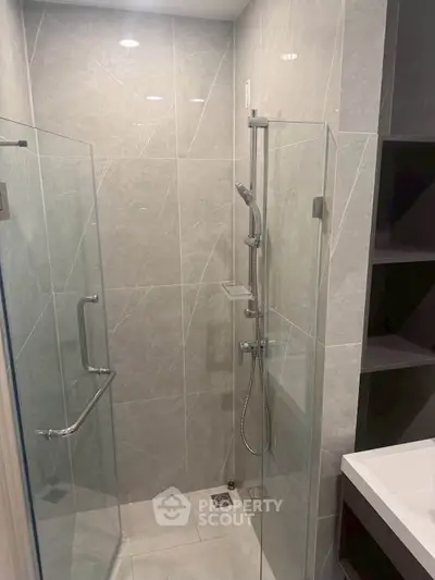 Modern bathroom with sleek glass shower enclosure and elegant tile design.