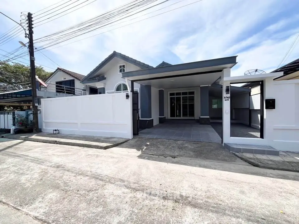 Charming single-story home with spacious driveway and modern facade in a serene neighborhood.