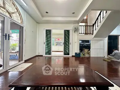 Spacious living room with wooden flooring and sliding glass doors opening to a garden view.