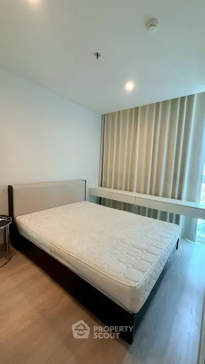 Spacious bedroom with modern decor and large window for natural light