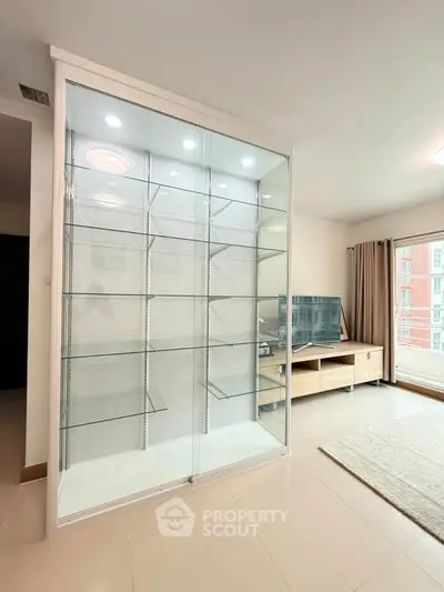 Spacious living room with modern glass display cabinet and large TV unit, perfect for stylish urban living.