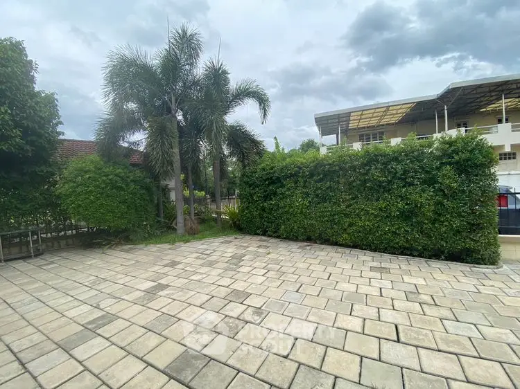 Spacious outdoor patio with lush greenery and palm trees, perfect for relaxation and entertainment.
