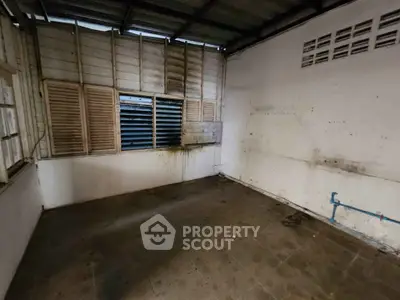 Spacious room with potential for renovation, featuring large windows and ample natural light.