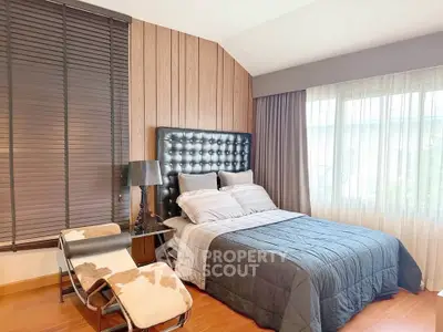 Cozy bedroom with stylish decor and large window for natural light