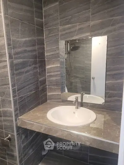 Modern bathroom with sleek gray tiles and a stylish sink.