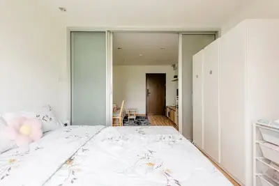 Bright and cozy bedroom with floral bedding and sliding doors leading to a living area.