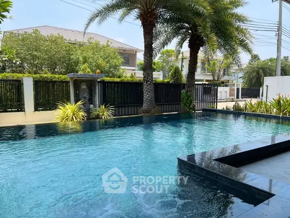 Luxurious private pool with palm trees in a serene residential setting.