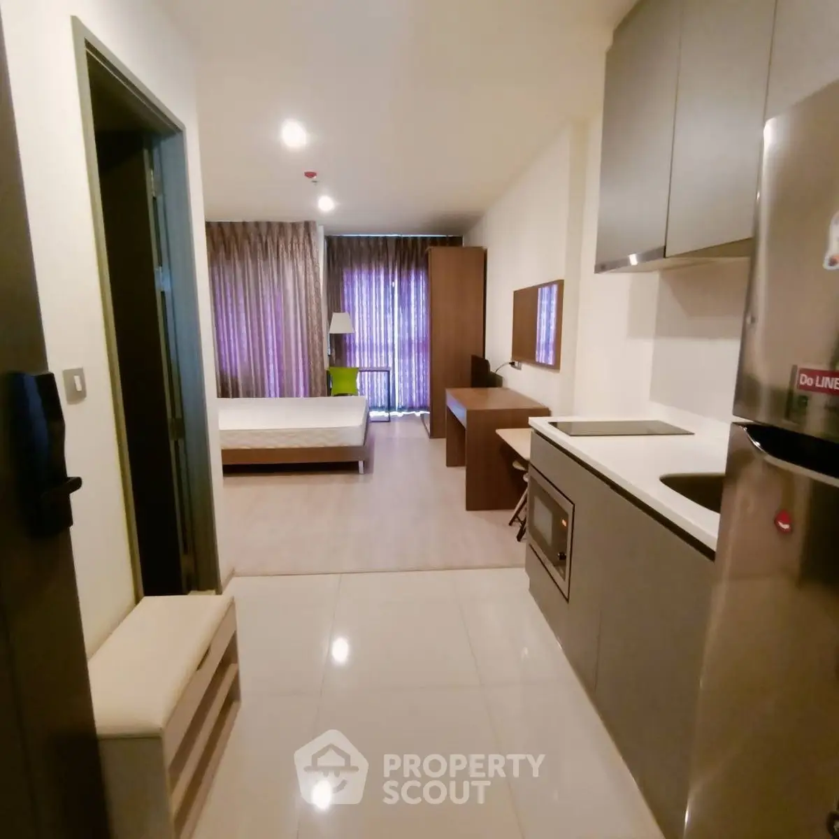 Modern studio apartment with open layout, sleek kitchen, and cozy bedroom area.