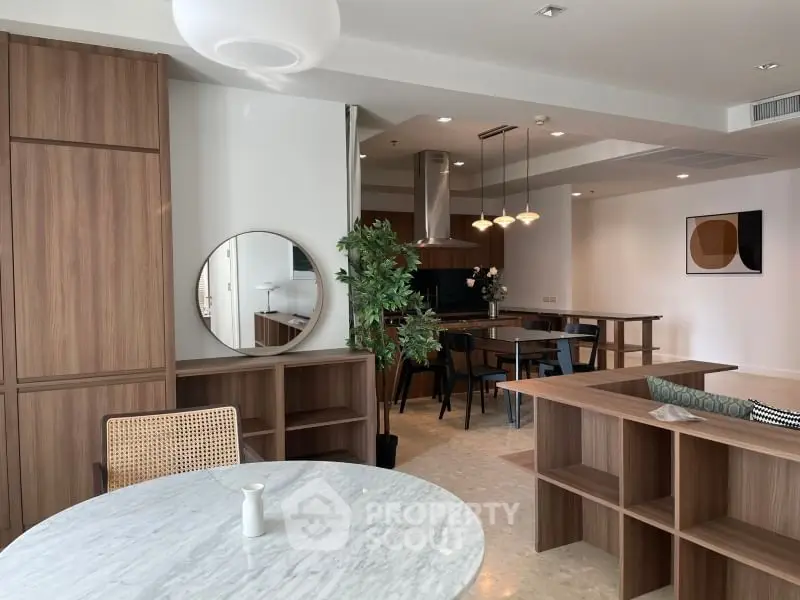 Modern open-plan living and dining area with stylish wooden furniture and elegant decor.