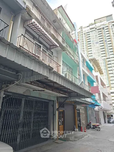 Explore this urban building exterior with multiple balconies and a modern high-rise backdrop.