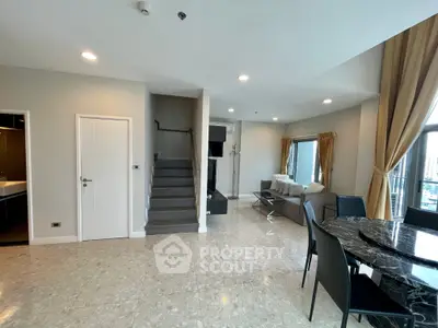Spacious modern living room with marble flooring and elegant furniture in a high-rise apartment.