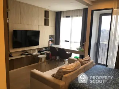 Modern living room with balcony view, featuring sleek furniture and natural light.